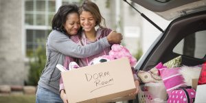 African American mother helping daughter pack for college